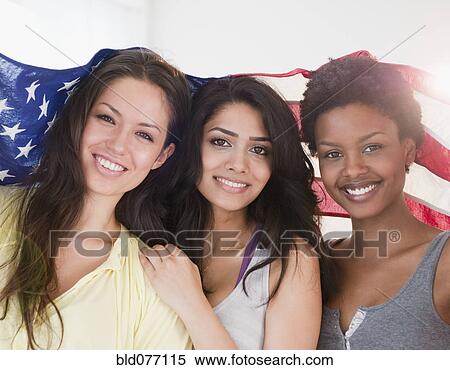 Friends wrapping themselves in American flag View Large Photo Image Stock Photography - Friends wrapping themselves in American flag. Fotosearch
