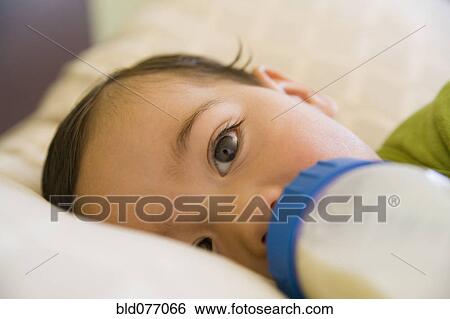 Stock Photograph - Hispanic baby boy drinking bottle. Fotosearch