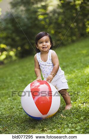 Stock Photography - Hispanic baby boy playing with ball. Fotosearch