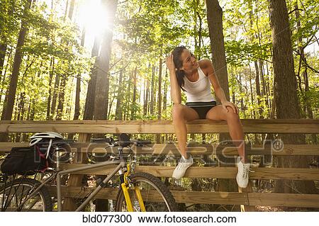 Hispanic cyclist sitting on bridge railing View Large Photo Image Stock Image - Hispanic cyclist sitting on bridge railing. Fotosearch