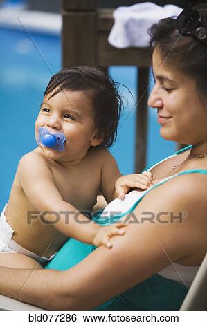 Stock Photograph - Hispanic mother holding baby boy. Fotosearch