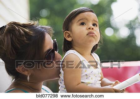 Stock Photo - Hispanic mother kissing baby boy. Fotosearch