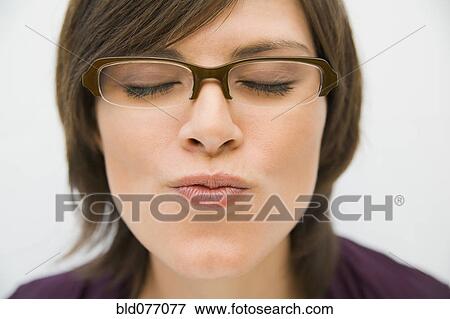 Stock Photo - Hispanic woman in eyeglasses puckering for kiss. Fotosearch