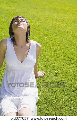 Hispanic woman relaxing on grass View Large Photo Image Stock Photo - Hispanic woman relaxing on grass. Fotosearch