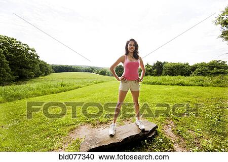 Hispanic woman standing on rock in field View Large Photo Image Stock Image - Hispanic woman standing on rock in field. Fotosearch