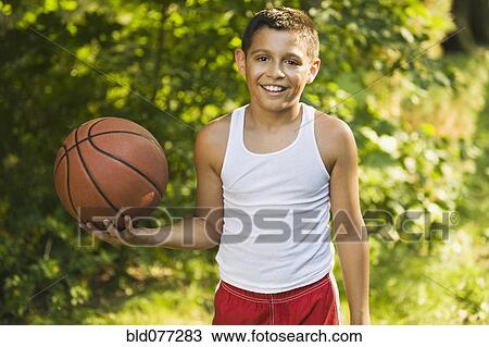 Mixed race boy holding basketball View Large Photo Image Stock Image - Mixed race boy holding basketball. Fotosearch
