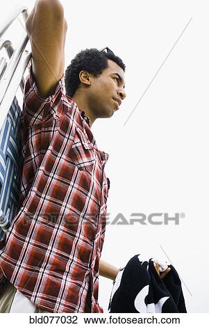 Mixed race man carrying lounge chair View Large Photo Image Stock Image - Mixed race man carrying lounge chair. Fotosearch