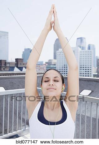 Stock Photo - Mixed race woman exercising with mp3 player. Fotosearch