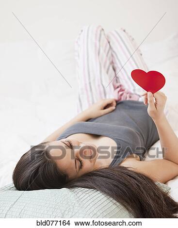 Mixed race woman holding red paper heart View Large Photo Image Picture - Mixed race woman holding red paper heart. Fotosearch