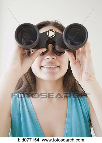 Picture - Mixed race woman looking through binoculars. Fotosearch