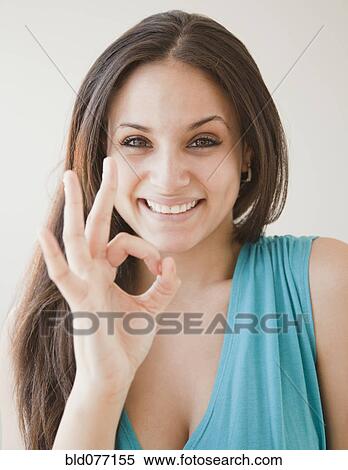 Stock Photography - Mixed race woman making ok symbol. Fotosearch