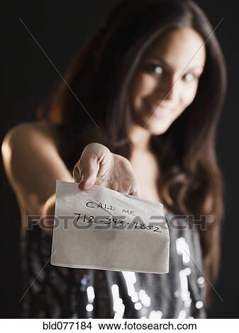 Picture - Mixed race woman offering phone number on napkin. Fotosearch