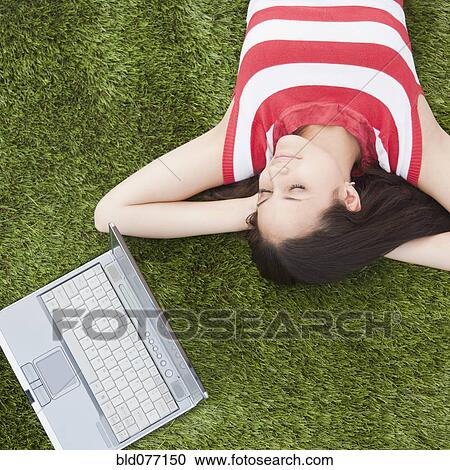 Mixed race woman sleeping in grass with laptop View Large Photo Image Stock Image - Mixed race woman sleeping in grass with laptop. Fotosearch