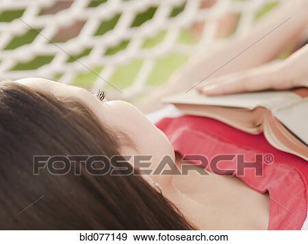 Stock Photo - Mixed race woman sleeping in hammock. Fotosearch