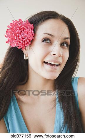 Stock Photograph - Mixed race woman with flower in hear. Fotosearch