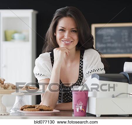 Stock Image - Mixed race woman working on coffee shop. Fotosearch