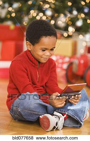 African boy playing video game at Christmas View Large Photo Image Stock Photo - African boy playing video game at Christmas. Fotosearch