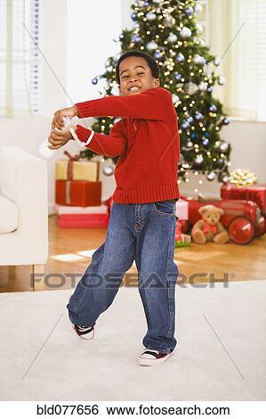 African boy playing video game at Christmas View Large Photo Image Stock Photograph - African boy playing video game at Christmas. Fotosearch