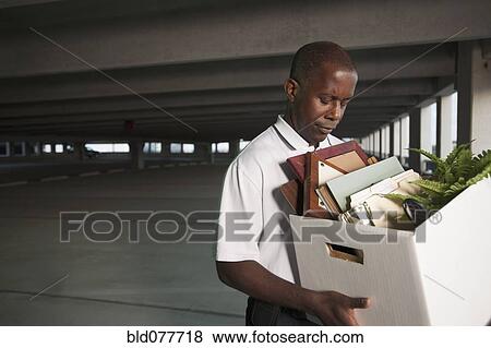 Stock Photo - African businessman carrying personal belongings. Fotosearch