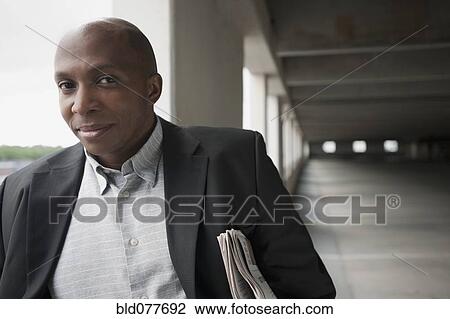 Stock Image - African businessman standing in parking garage. Fotosearch