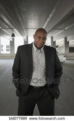 Stock Photo - African businessman standing in parking garage. Fotosearch