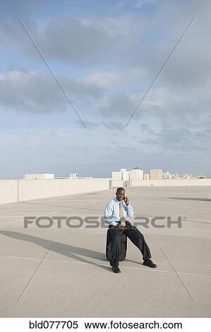 Stock Photography - African businessman waiting in parking lot. Fotosearch