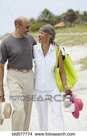 Picture - African couple walking on beach. Fotosearch