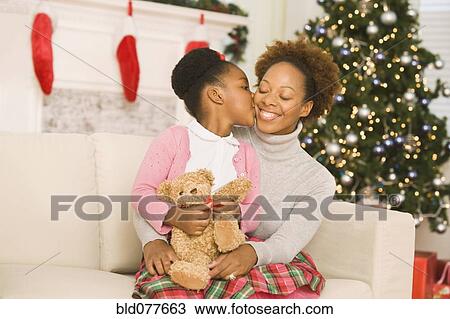 African girl kissing mother at Christmas View Large Photo Image Stock Image - African girl kissing mother at Christmas. Fotosearch