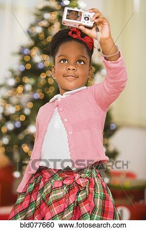 African girl taking self-portrait at Christmas View Large Photo Image Stock Image - African girl taking self-portrait at Christmas. Fotosearch