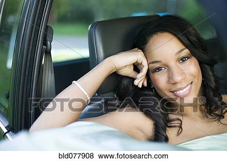 Stock Photo - African woman sitting in passenger seat of car. Fotosearch