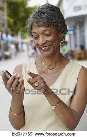African woman text messaging on cell phone View Large Photo Image Stock Photo - African woman text messaging on cell phone. Fotosearch