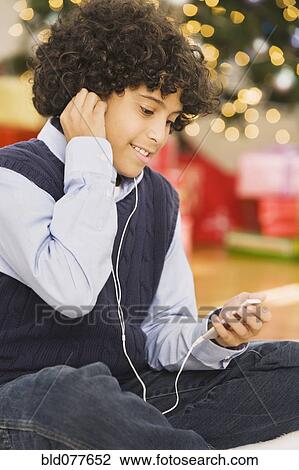 Hispanic boy listening to mp3 player at Christmas View Large Photo Image Stock Image - Hispanic boy listening to mp3 player at Christmas. Fotosearch
