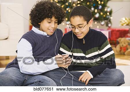 Hispanic brothers sharing mp3 player at Christmas View Large Photo Image Stock Image - Hispanic brothers sharing mp3 player at Christmas. Fotosearch