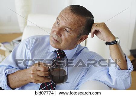 Stock Image - Hispanic businessman drinking coffee. Fotosearch