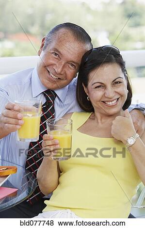 Hispanic couple drinking orange juice View Large Photo Image Stock Photo - Hispanic couple drinking orange juice. Fotosearch