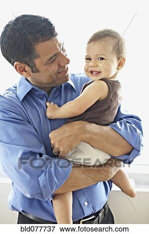Hispanic father holding daughter View Large Photo Image Stock Photo - Hispanic father holding daughter. Fotosearch