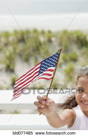 Stock Photography - Hispanic girl holding American flag. Fotosearch