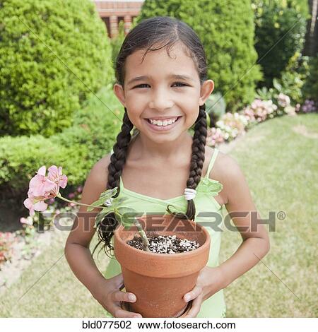 Hispanic girl holding potted plant View Large Photo Image Stock Image - Hispanic girl holding potted plant. Fotosearch