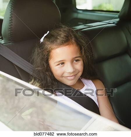 Stock Image - Hispanic girl in back seat of car. Fotosearch
