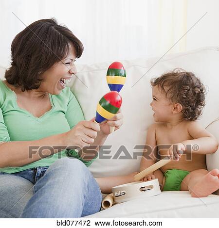 Stock Image - Hispanic mother and daughter making music. Fotosearch