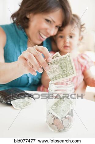 Hispanic mother and daughter saving money View Large Photo Image Stock Photo - Hispanic mother and daughter saving money. Fotosearch