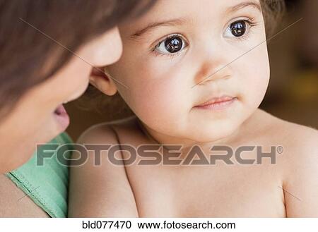Stock Image - Hispanic mother bonding with daughter. Fotosearch