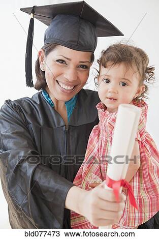 Hispanic mother graduate holding daughter and diploma View Large Photo Image Stock Image - Hispanic mother graduate holding daughter and diploma. Fotosearch