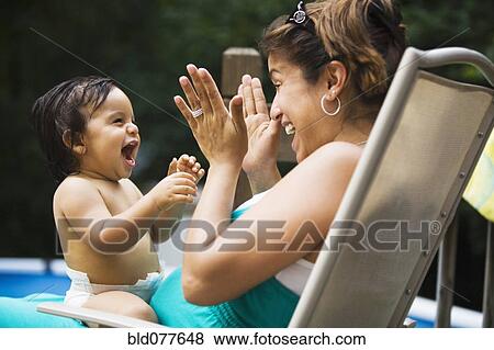 Hispanic mother playing with baby boy View Large Photo Image Stock Photo - Hispanic mother playing with baby boy. Fotosearch