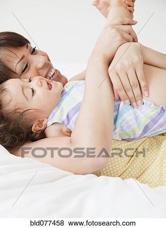 Stock Photo - Hispanic mother playing with daughter. Fotosearch