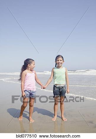 Hispanic sisters holding hands on beach View Large Photo Image Stock Image - Hispanic sisters holding hands on beach. Fotosearch