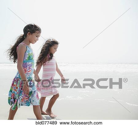 Hispanic sisters walking on beach View Large Photo Image Stock Photo - Hispanic sisters walking on beach. Fotosearch