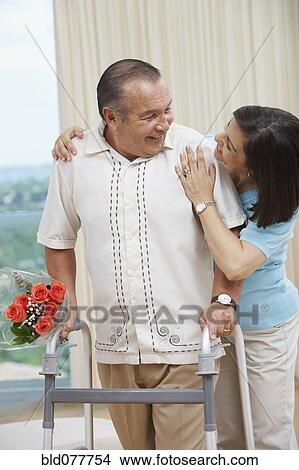 Hispanic woman encouraging husband using walker View Large Photo Image Picture - Hispanic woman encouraging husband using walker. Fotosearch