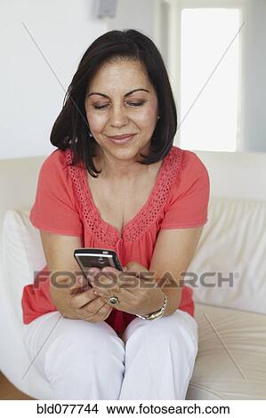 Hispanic woman text messaging on cell phone View Large Photo Image Picture - Hispanic woman text messaging on cell phone. Fotosearch