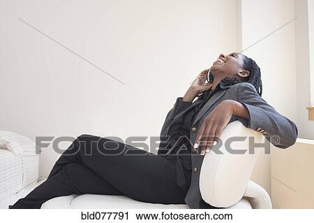 Stock Image - Mixed race businesswoman talking on cell phone. Fotosearch